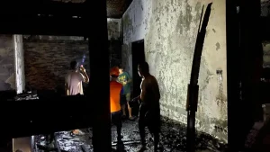 petugas-saat-melakukan-pembasahan-di-rumah-susanto-warga-karangsentul-gondangwetan-yang-terbakar-WgZct